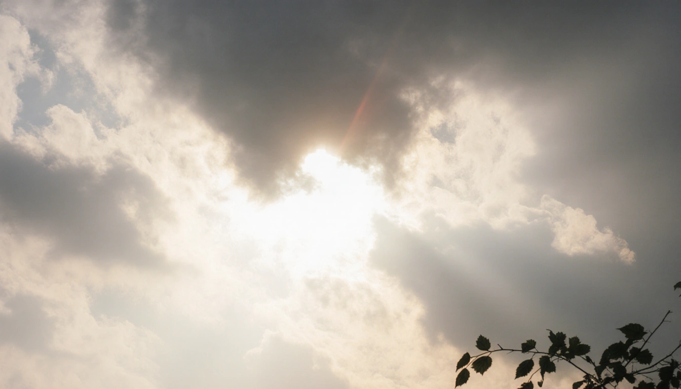 Sun rays streaming through gaps in morning clouds with a warm glow over the landscape
