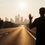 Figure raising hands in surrender on deserted highway with sunset glow and Austin skyline visible through trees