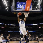 AJ Dybantsa dunking with BYU logo and number 23 visible while the Cougars score glows in the background