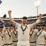Australian cricket team celebrating victory with captain Pat Cummins raising arms and fans waving Australian flags