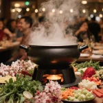 Lively hot pot displays ingredients and decorations with holiday lighting at a Christmas table.