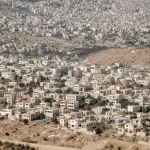 Israeli Cabinet members debating new settlements with a flag and map showing West Bank locations