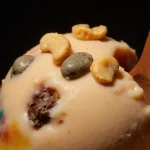 Frozen dessert showing small stones inside with creamy texture under warm light highlighting consumer safety concerns