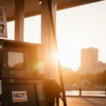 Gas pump pumping fuel with orange sunset glow and faded
