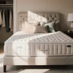 Marshmallow‑like tufted mattress resting in soft natural light with decorative pillows and an open closet door