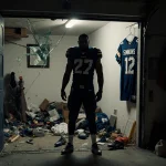 Jeffery Simmons standing in dimly lit garage with scattered football jerseys and a shattered mirror hanging crookedly