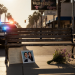 Police car standing behind bench with wildflowers and distant Walk of Fame under golden hour