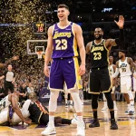 Luka Doncic stands confidently at center court while LeBron James grins beside him confetti falls.