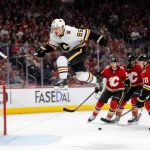 Macklin Celebrini soaring, unleashing a spin‑orama hockey goal, skate on ice teammates cheer.