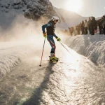 Marco Schwarz victorious holding giant slalom pole with gloved hand and skis slightly ajar on snowy slope