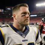 Matthew Stafford standing with Rams lights on his face and a red to yellow gradient.