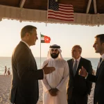 Dignitaries standing under a shaded gazebo with a Miami beach sunset and a subtle American flag