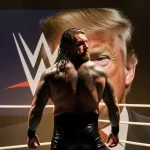 Mick Foley standing alone with back to camera and disappointed expression beside a dimly lit WWE ring