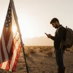Lone migrant standing at a border crossing looking at a phone screen with a CBP Home App in a desert sunset.