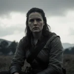 Morgan Geyser sits in worn clothing in rural scene under overcast sky with lone figure walking away into darkness.