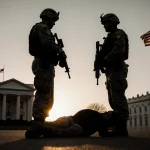Guard troops stand with wounded soldier on ground and suspect looks toward White House under sunset.