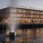 Modern building with warm golden light and a sleek metallic pipe emitting vapor showing heat recovery near riverfront