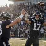 Blake Horvath tossing a football with Eli Heidenreich catching it and celebrates their 17-16 victory under autumn sun