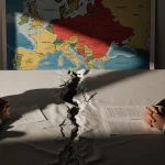 President Zelenskyy and an American diplomat negotiating at a tablecloth with a 20‑point plan red‑highlighted Ukraine map