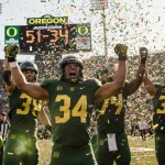 Oregon football players celebrating victory with confetti and a scoreboard showing 51-34 at Autzen Stadium on a sunny day