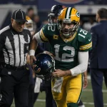 Jordan Love is being helped off the field with helmet and a shocked look during football injury while Bears bench appears thr