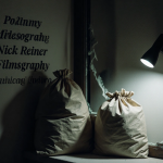 Spotlight illuminates a stack of police evidence bags and a torn fabric in a shattered window frame with blurred background