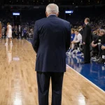 Rick Pitino standing on State Farm Arena court with St. John