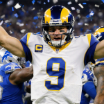 Matthew Stafford celebrates victory with arms raised and confetti swirling around him in a stadium backdrop