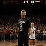 Longhorns players standing with disappointed faces and the 3‑1 scoreboard behind them in a dim gym.