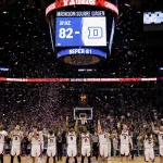 Texas Tech players celebrating win with scoreboard 82-81 and confetti while fans cheer in Madison Square Garden