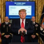 President Trump speaking at podium in Oval Office with flags in walls and screen showing $1,776 bonus check military crowd