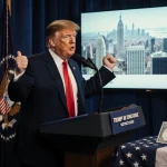 President Donald Trump stands at a podium with a $1,776 bonus check and an American flag in the background
