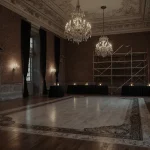Unfinished ballroom shines with flickering candles and chandeliers revealing exposed brick walls and a marble dance floor.