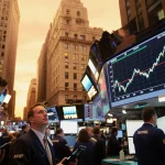 Wall Street traders watching sharp tech stock graph with glowing screens and orange dusk lighting