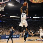 Zion Williamson performing a slam dunk with number 7 and cheering fans at Smoothie King Center.