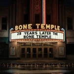 Vintage movie theater marquee glows with golden letters advertising 28 Years Later The Bone Temple with wet pavement reflecti