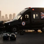 Ambulance speeds away from wreck with British flag and Anthony Joshua silhouette visible in window on Lagos expressway