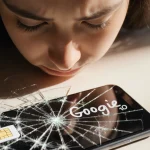 Frustrated person staring at shattered phone screen with number fragments and a blurred Google Pixel 10 on a table.