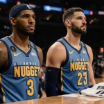 Aaron Gordon and Christian Braun standing on the Denver Nuggets bench with light reveals their faces after injury and a disca