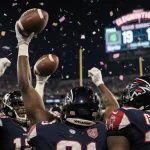 Falcons players celebrating with confetti and footballs around captain and scoreboard showing 19-17 in dimly lit stadium
