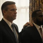 Governor Reeves stands beside Marcus Taylor with hand on shoulder while Marcus is cuffed and Maurice Taylor looks hopeful for