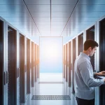 Technicians working on computer screens with humming modern servers and a blue gradient backdrop