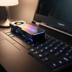 Laptop glowing with warm lamp light and revealing bright RTX 5070 GPU module through its transparent lid