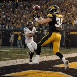 Mark Gronowski releases the ball with Reece Vander Zee leaping to catch it while a Vandy kicker watches glow Iowa football