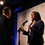 Jasmine Crockett speaking with a spotlight on her face while Talarico faces her across the hall Texas AFL‑CIO windows behind.