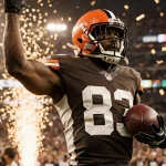 Myles Garrett pounces on Bengals quarterback with ball flying out while confetti explodes around him.