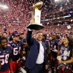 Ole Miss players celebrate victory with confetti and a trophy in hand near Coach Kirby Smart.