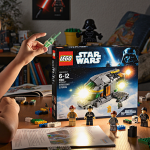 Child excitedly holds a glowing Star Wars Lego set with interactive bricks and minifigures and a warm glow from the set light