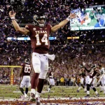 Brad Jackson leaps for touchdown celebration amid confetti exploding around him in AT&T Stadium