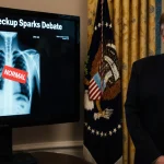President Trump stands behind Oval Office desk with screen showing heart and lungs image sticker banner reads Trump